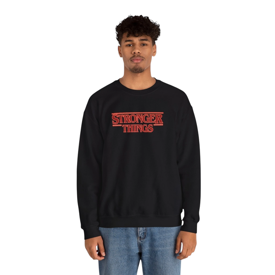 DailyThreadCo. black crewneck sweatshirt with red "STRONGER THINGS" logo embroidery, 50/50 cotton-polyester blend, classic fit.