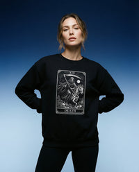 DailyThreadCo. black crewneck sweatshirt with a white Death tarot card graphic featuring a skeleton reaper on a horse. Gothic style.