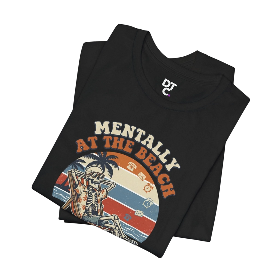 DailyThreadCo black 100% cotton t-shirt with a retro graphic of a skeleton relaxing on a beach chair under palm trees, text reads "Mentally at the Beach".