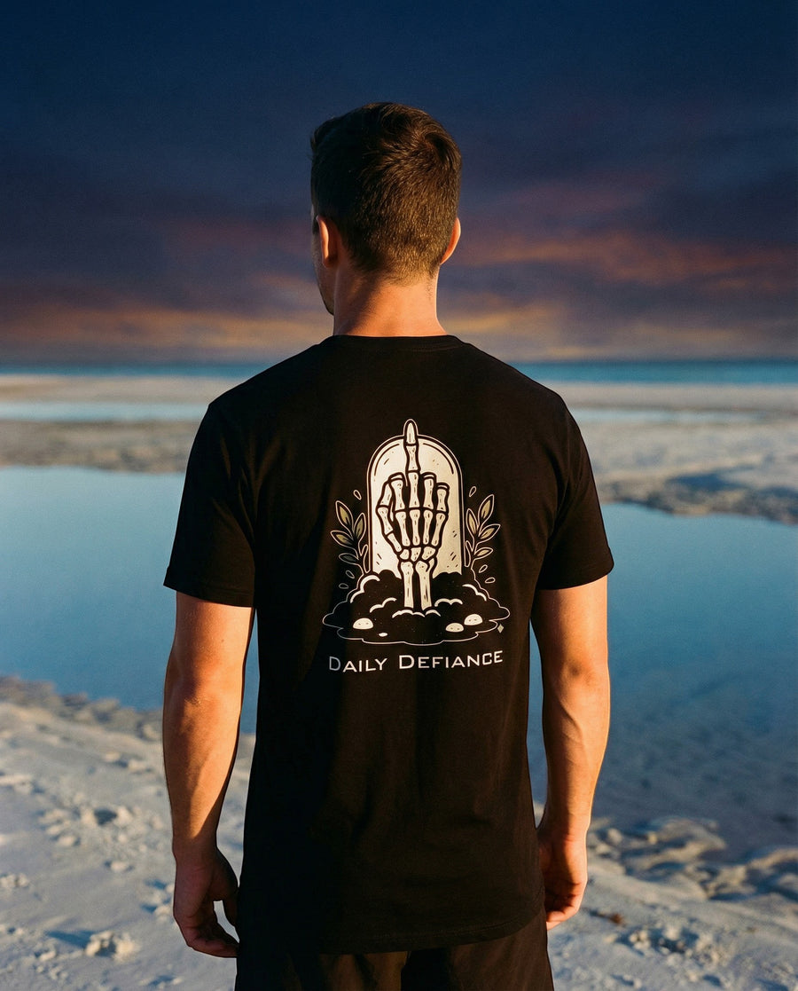 DailyThreadCo. black 100% cotton t-shirt with a graphic of a skeleton hand rising from earth with "Daily Defiance" text.