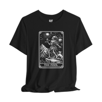 DailyThreadCo. black 100% cotton t-shirt with 'The Fool' tarot card graphic. Features skeleton figure, dog, mountains, and sun.