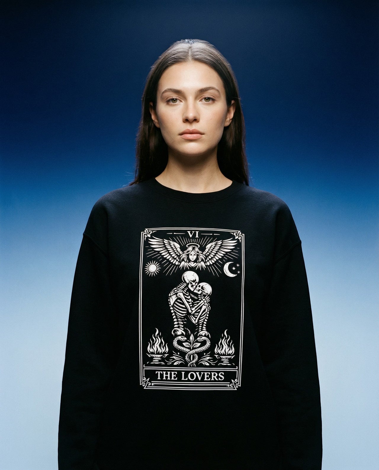 DailyThreadCo. black crewneck sweatshirt with 'The Lovers' tarot card graphic featuring skeleton figures, angelic wings, sun, moon, and flames.