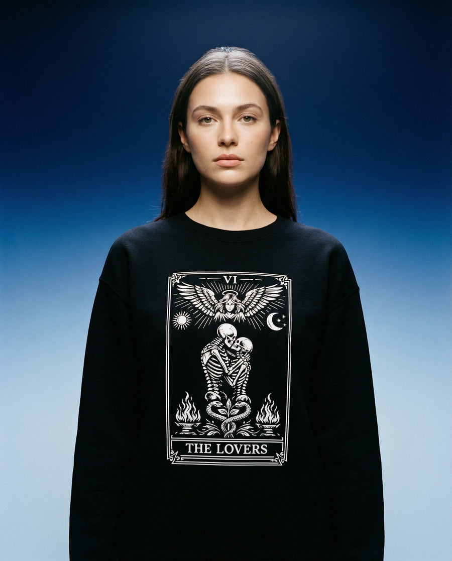 DailyThreadCo. black crewneck sweatshirt with 'The Lovers' tarot card graphic featuring skeleton figures, angelic wings, sun, moon, and flames.