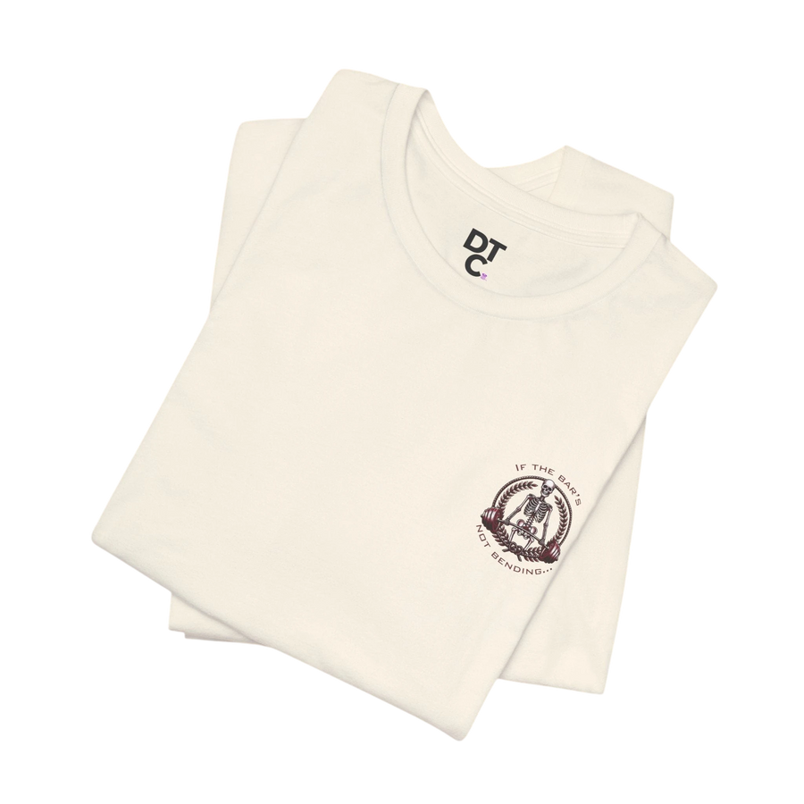 DailyThreadCo. cream 100% cotton crew neck t-shirt with a skeleton weightlifter graphic on the chest.