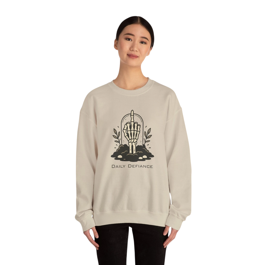 DailyThreadCo. cream crewneck sweatshirt with a skeleton hand graphic giving the middle finger, surrounded by foliage and text Daily Defiance.