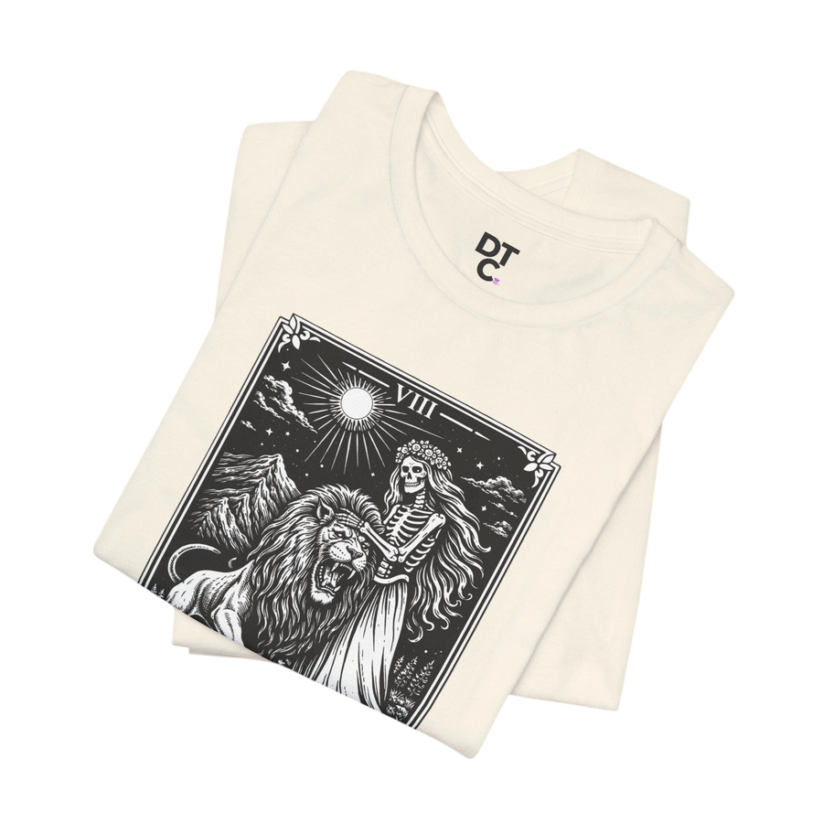 DailyThreadCo. cream 100% cotton t-shirt with vintage Strength tarot card illustration of a skeleton woman and a lion.