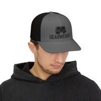 DailyThreadCo. grey trucker cap with black mesh back, featuring a distressed skull emblem and 