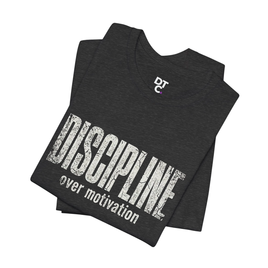 DailyThreadCo. dark grey cotton t-shirt with distressed white text reading "DISCIPLINE over motivation" and a small DTC logo.