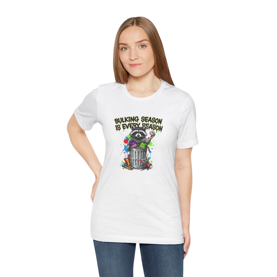 DailyThreadCo. white 100% cotton t-shirt with a graphic of a raccoon in a trash can, surrounded by colorful paint splatters and the text "BULKING SEASON IS EVERY SEASON".