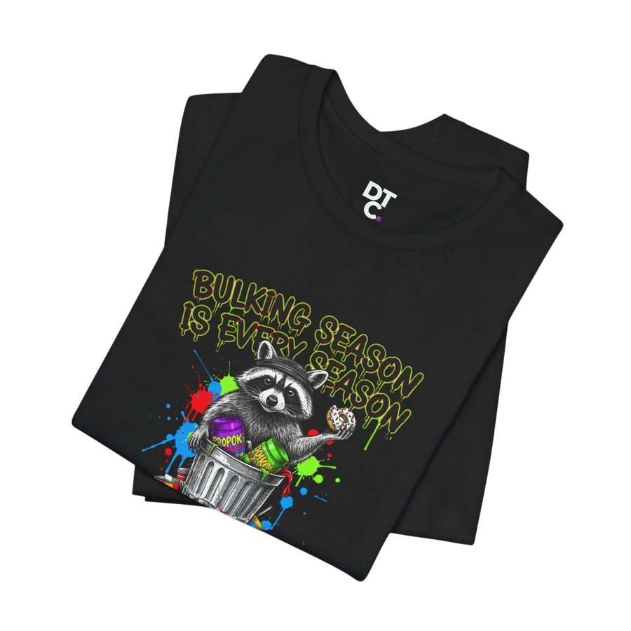 DailyThreadCo. black 100% cotton t-shirt with a funny graphic of a raccoon in a trash can holding a donut, text reads "BULKING SEASON IS EVERY SEASON".