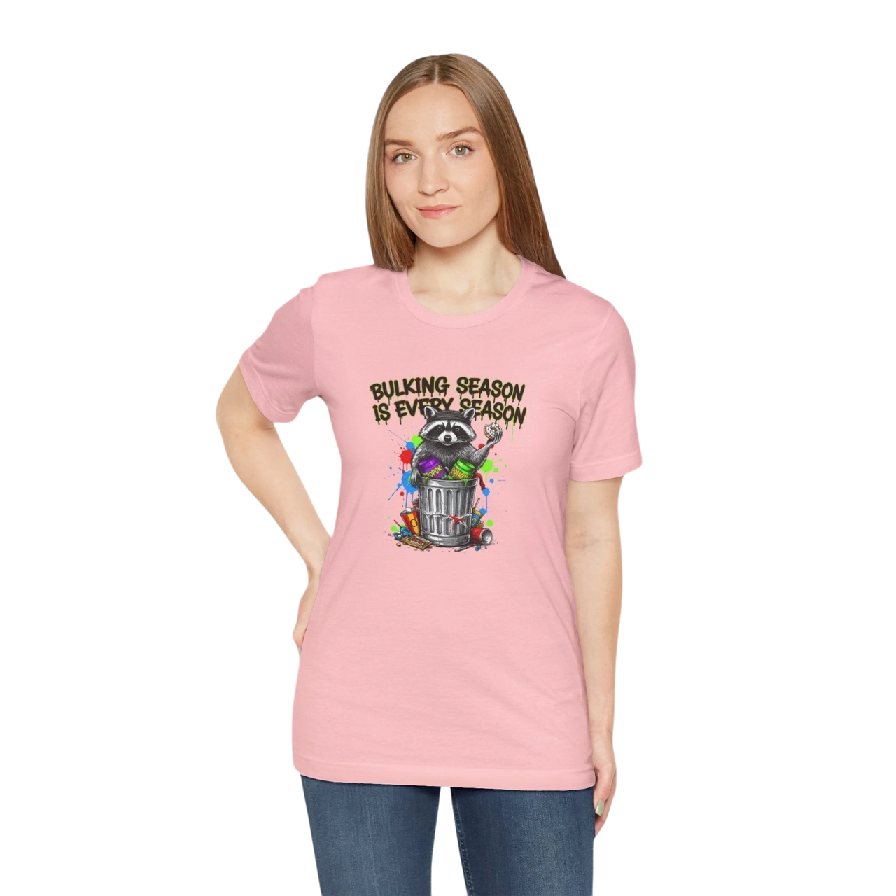 DailyThreadCo. pink 100% cotton t-shirt with a graphic of a raccoon in a trash can, surrounded by paint splatters and the text "BULKING SEASON IS EVERY SEASON".