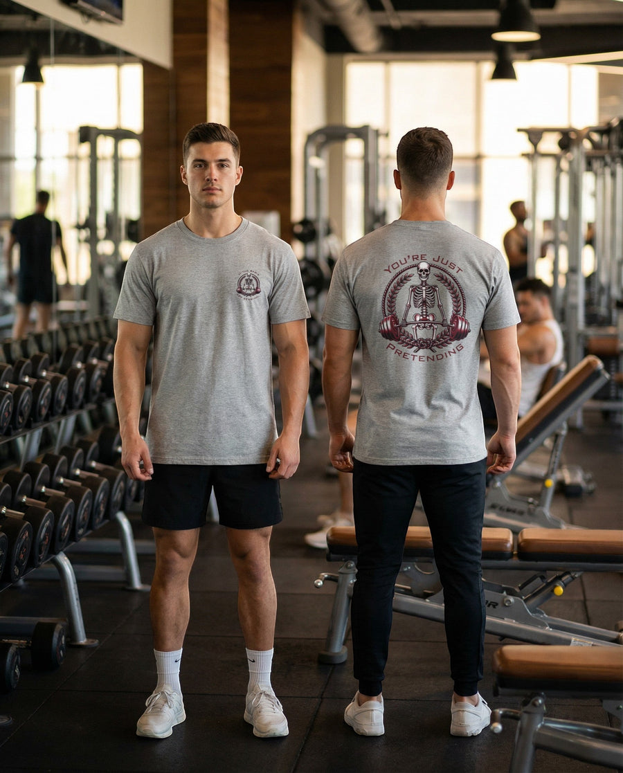 DailyThreadCo. grey 100% cotton t-shirt with skeleton weightlifter graphic on back and chest emblem. Model in gym.