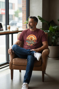 DailyThreadCo. maroon 100% cotton t-shirt with retro sunset graphic and surfer playing guitar.