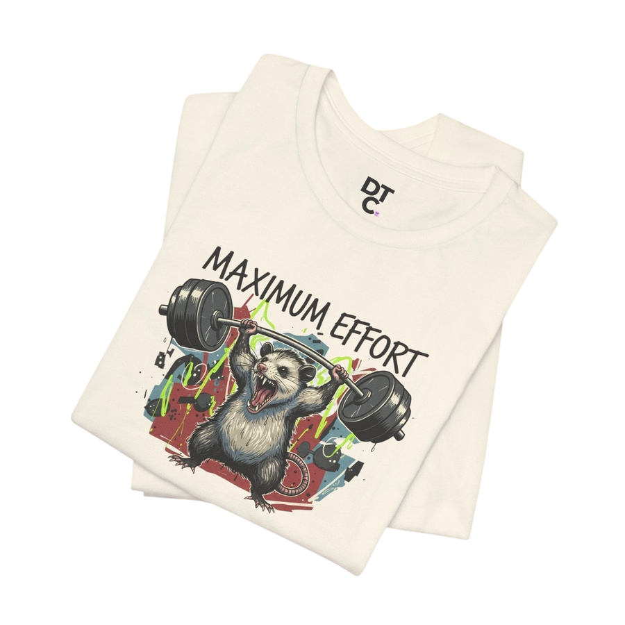 DailyThreadCo. cream cotton t-shirt with a graphic of a possum lifting a barbell and the text "MAXIMUM EFFORT".