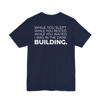 DailyThreadCo. navy blue cotton t-shirt with white text that reads 'WHILE YOU SLEPT. WHILE YOU RESTED. WHILE YOU WAITED. I WAS IN THE DARK. BUILDING.'
