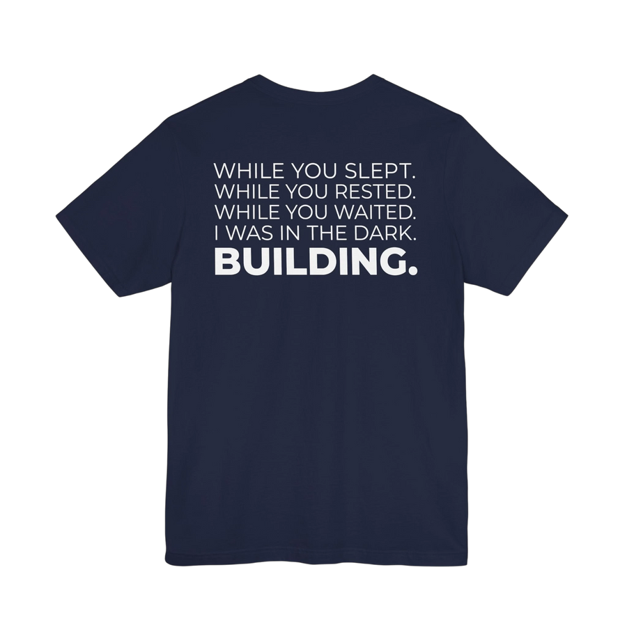 DailyThreadCo. navy blue cotton t-shirt with white text that reads 'WHILE YOU SLEPT. WHILE YOU RESTED. WHILE YOU WAITED. I WAS IN THE DARK. BUILDING.'