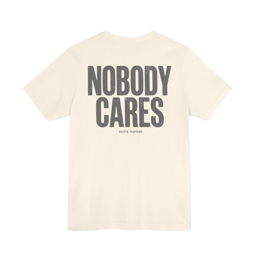 DailyThreadCo. cream cotton graphic tee with "NOBODY CARES" and "work harder" text art on back.