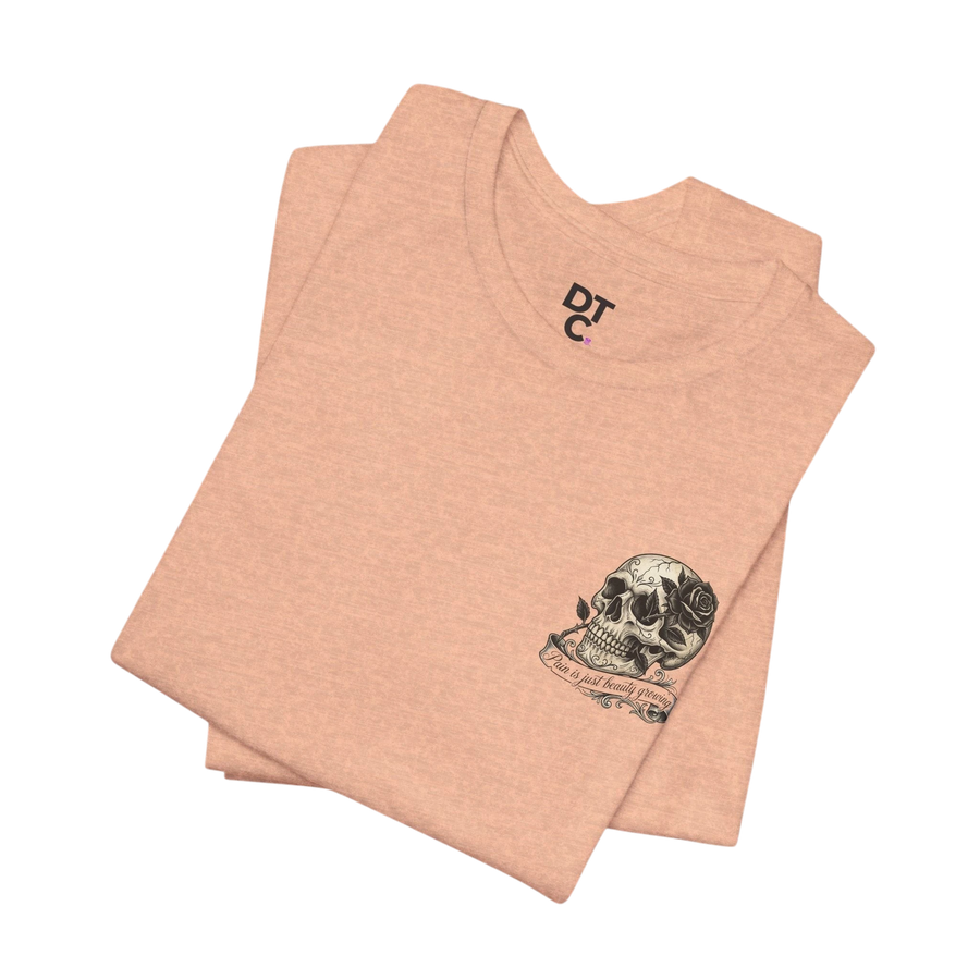 DailyThreadCo. peach-colored cotton t-shirt with a small, hand-drawn skull and rose graphic on the left chest.