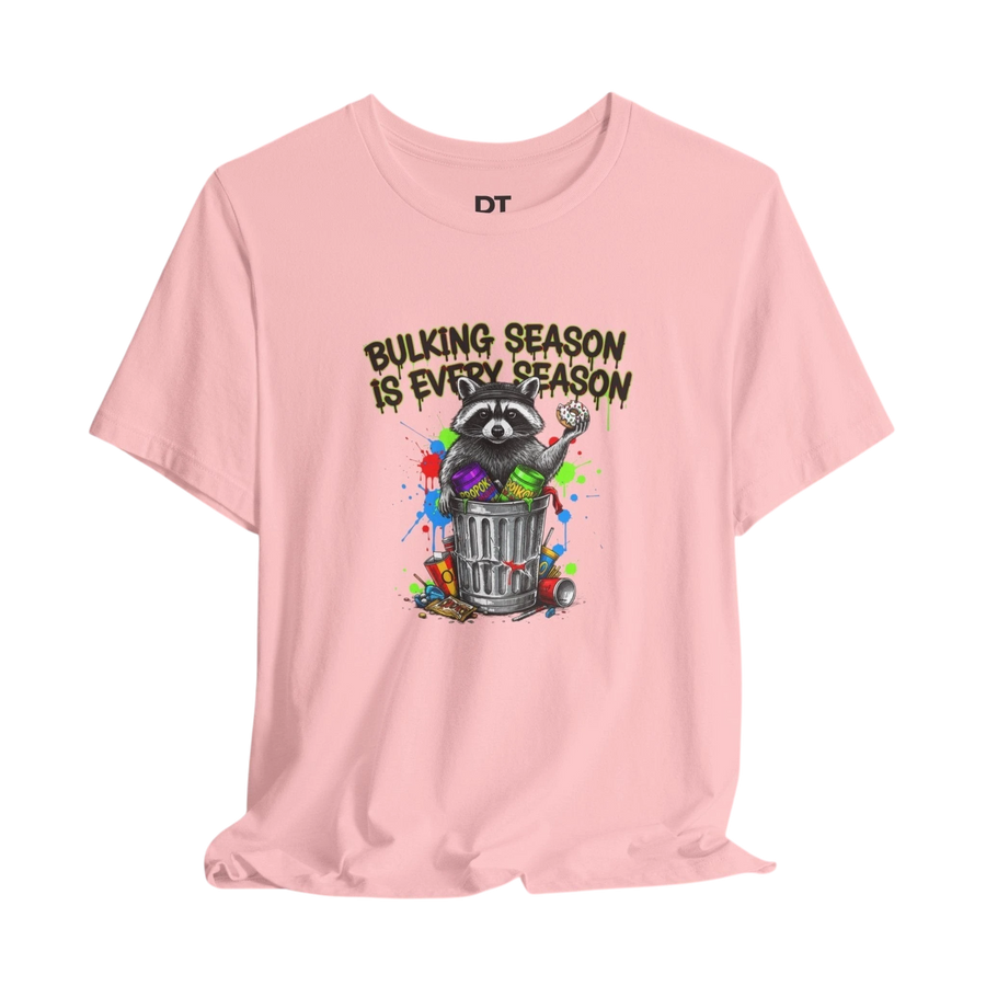 DailyThreadCo. pink 100% cotton t-shirt with a graphic of a raccoon in a trash can, holding a donut, with the text "BULKING SEASON IS EVERY SEASON".