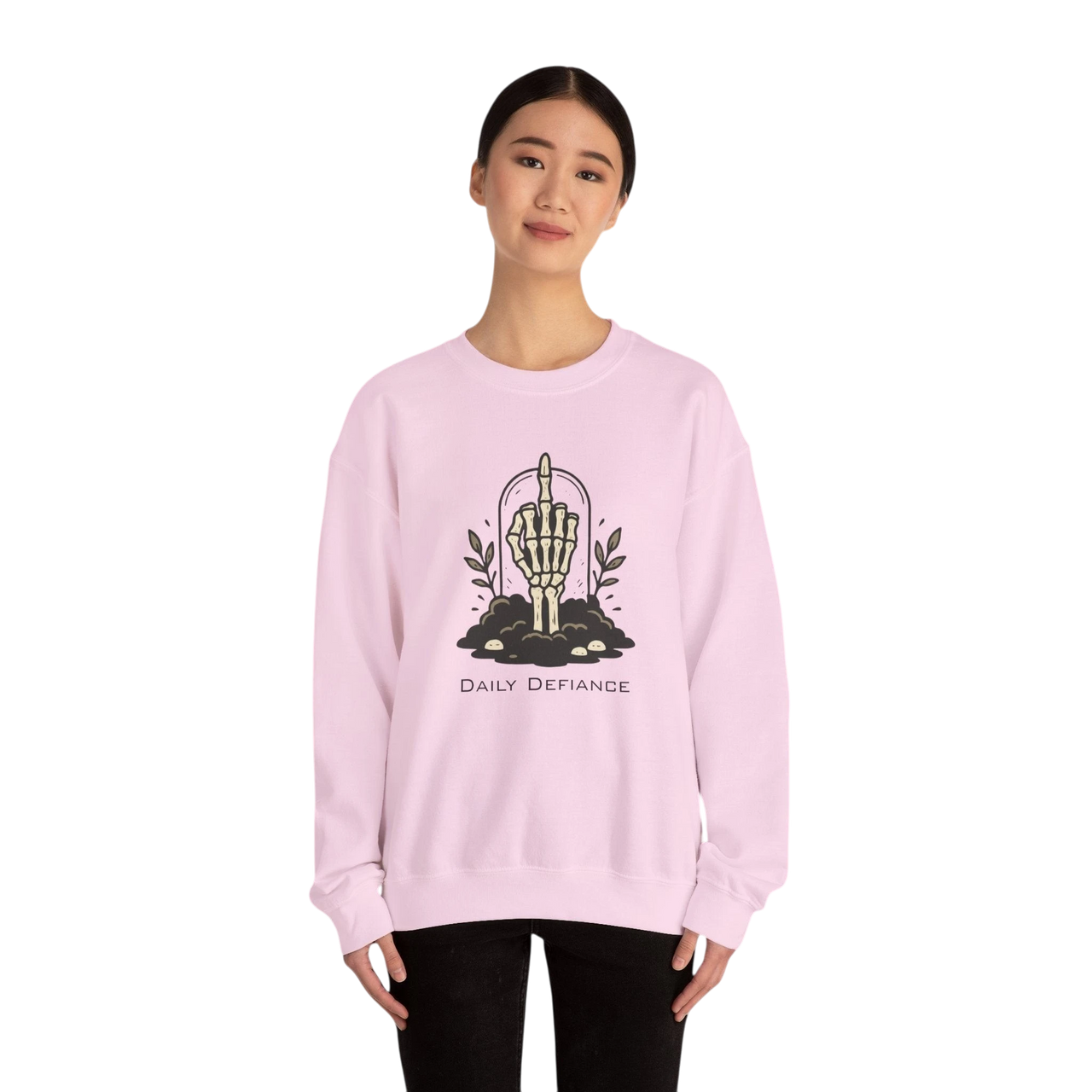 DailyThreadCo. light pink crewneck sweatshirt with a skeleton hand graphic giving the middle finger, surrounded by foliage and text "Daily Defiance".