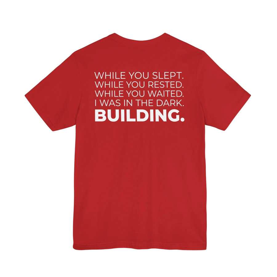DailyThreadCo. red cotton t-shirt with white text on back: 'While You Slept. While You Rested. While You Waited. I Was In The Dark. BUILDING.'