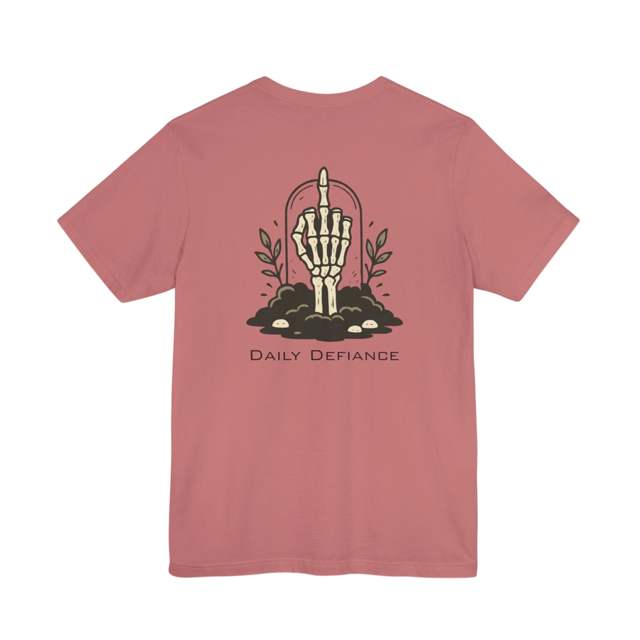 DailyThreadCo. Muted rose 100% cotton t-shirt with a graphic of a skeleton hand rising from the ground with leaves and the text Daily Defiance.