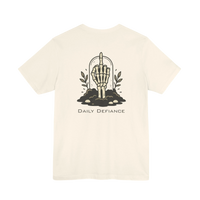 DailyThreadCo. cream 100% cotton t-shirt with a graphic of a skeleton hand rising from the ground with leaves and the text Daily Defiance.