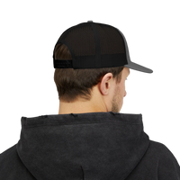 DailyThreadCo. black and grey trucker cap with distressed skull emblem and 'DEADWEIGHT' logo. Mesh back for breathability.