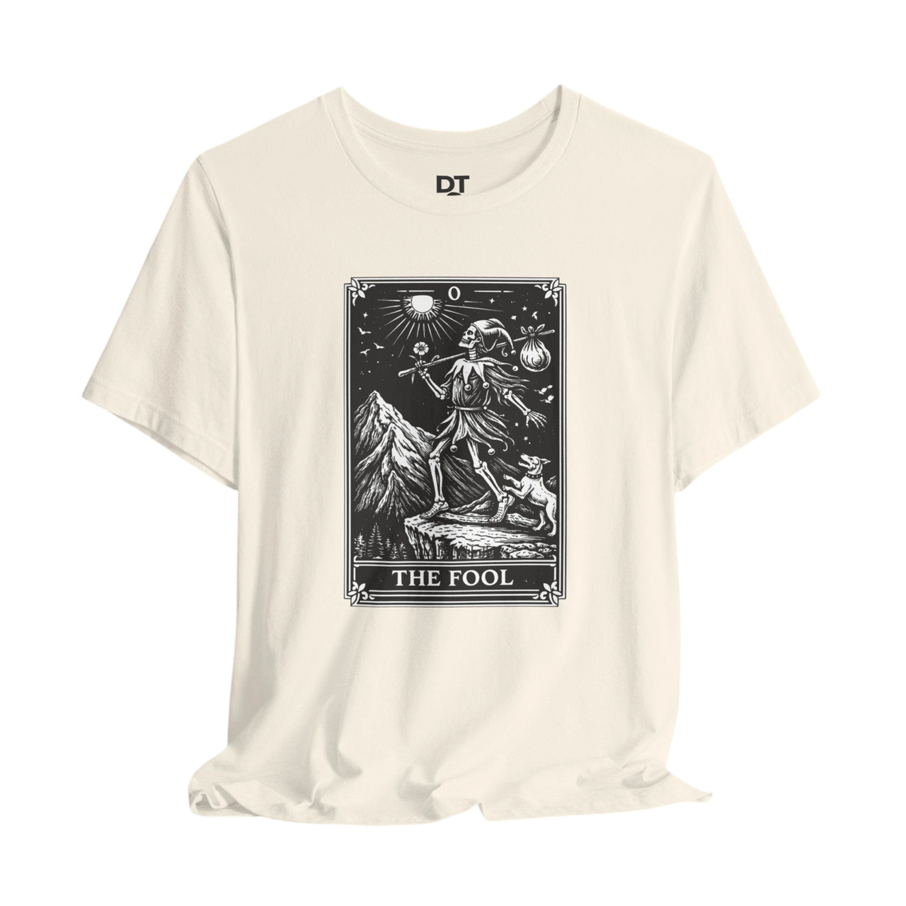 DailyThreadCo. cream cotton t-shirt with 'The Fool' tarot card graphic in black and white. Features a skeleton figure, dog, mountains, and sun.