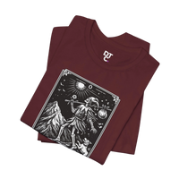 DailyThreadCo. maroon 100% cotton t-shirt with 'The Fool' tarot card graphic print. Features skeleton figure, mountain, sun, and dog.