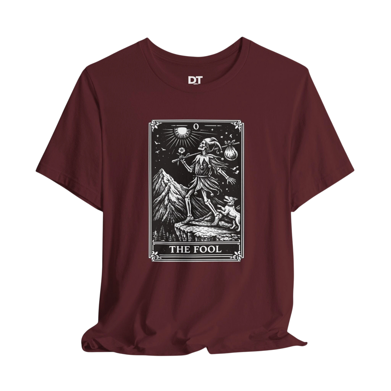 DailyThreadCo. maroon cotton t-shirt with 'The Fool' tarot card graphic print on front. Features skeleton figure, dog, mountains, and celestial symbols.