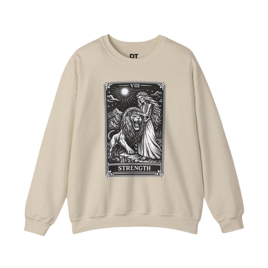 DailyThreadCo. beige crewneck sweatshirt with a black tarot strength card graphic featuring a skeleton woman and a lion.