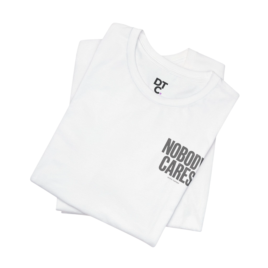 DailyThreadCo. white 100% cotton graphic tee with "Nobody Cares" text and DTC logo.