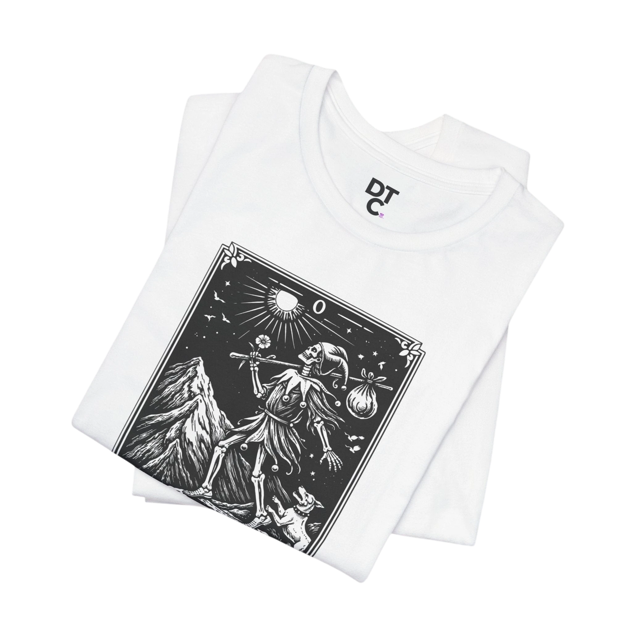 DailyThreadCo. white 100% cotton t-shirt with 'The Fool' tarot card graphic in black and white, featuring a skeleton figure, mountain, and celestial elements.